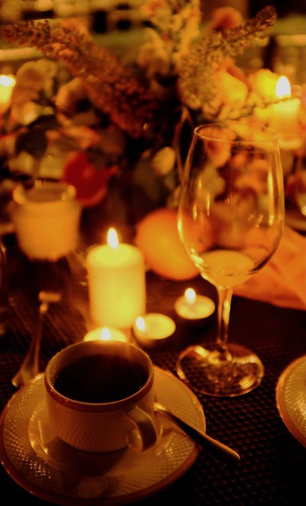 Tea Cup and Wineglass in Front of Candles